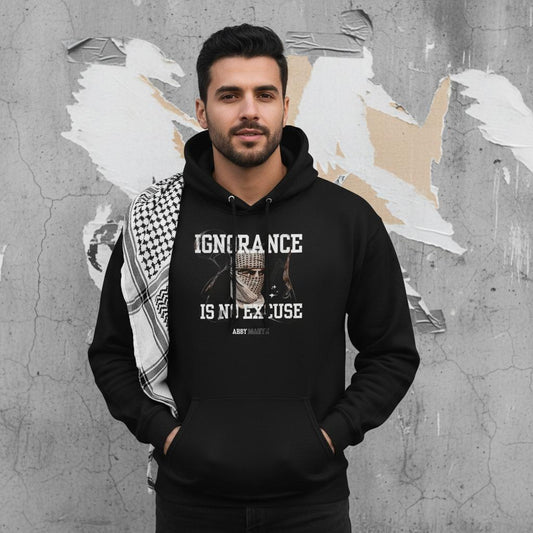 Abby Martin - Ignorance is No Excuse | handsome arab man wearing kuffiyeh on shoulders with hands in pockets. image for upper half only. background old cracked wall with some torn plain posters and torn out duct-tape. black and white image. only model in full color with glowing light on model