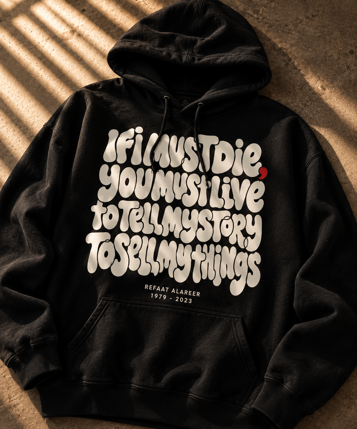 black hoodie on the floor closeup with part of poem from poet from Gaza If I must Die, you must live