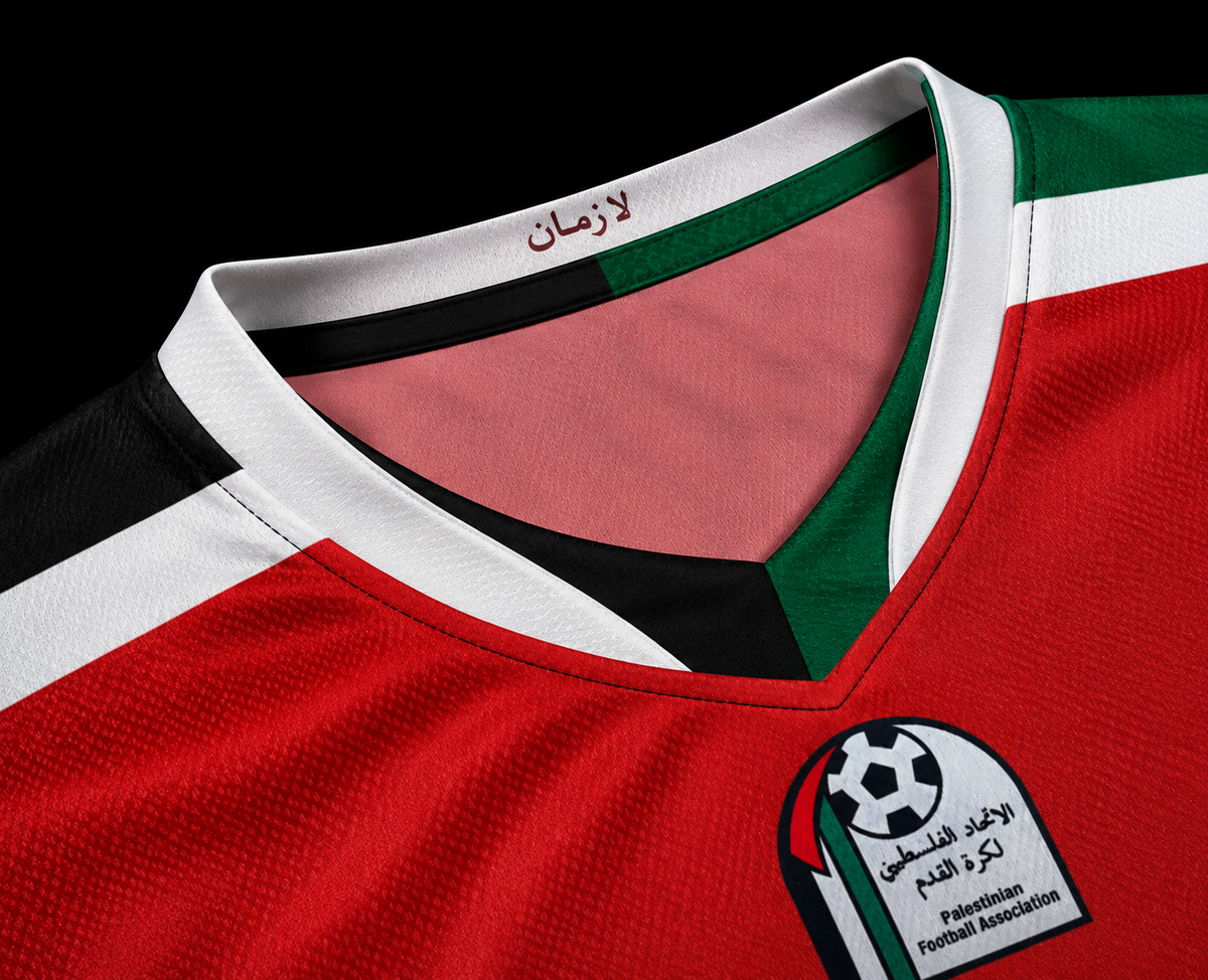 Close-up of a red soccer jersey with green and white shoulder stripes, a black inner collar trim, and a Palestine Football Association patch on the chest.