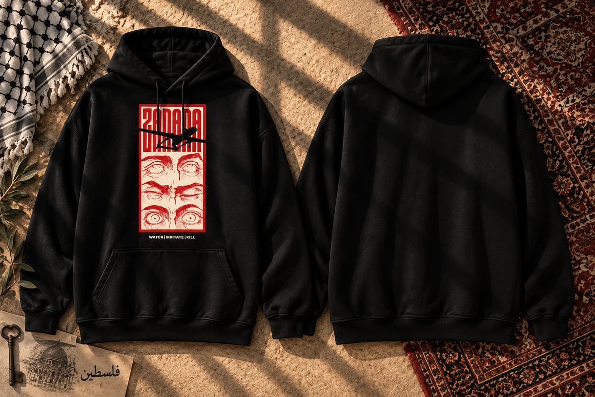 Two black hoodies shown flat on a textured beige surface with warm shadows, one front view and one back view. The front hoodie features a red rectangular graphic with stylized eyes and a black bird silhouette across the chest.