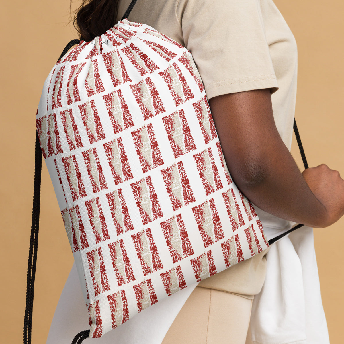 woman carrying a drawstring back with the Palestinian map pattern in tatter embroidery style
