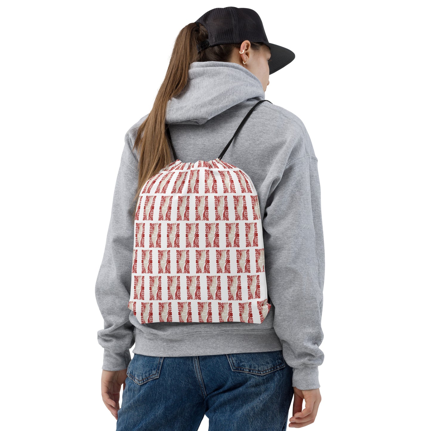 Young lady wearing a drawstring bag on her back and a cap. the drawstring bag is in a traditional Palestinian map in tatreez embroidery style
